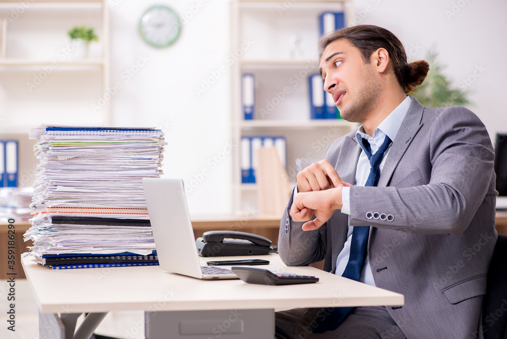 Young male businessman unhappy with excessive work