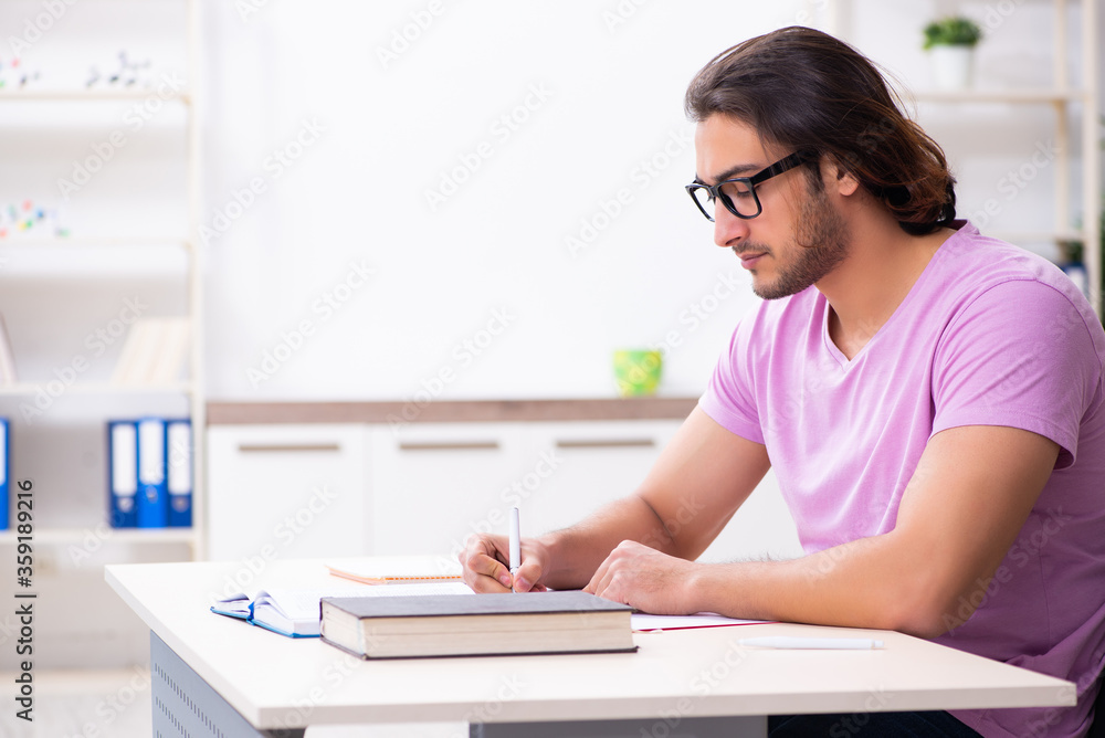 Young male student preparing for exams at classroom Young male student preparing for exams at classroom