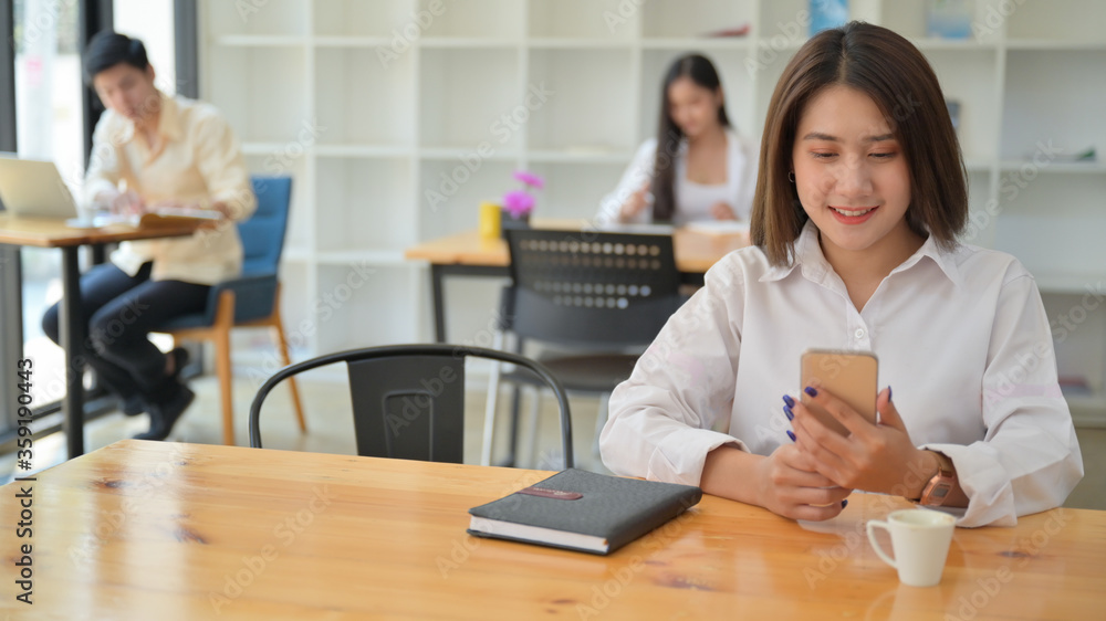Women using smartphone in the Cafe.They sit in social distancing. Women using smartphone in the Cafe.They sit in social distancing.