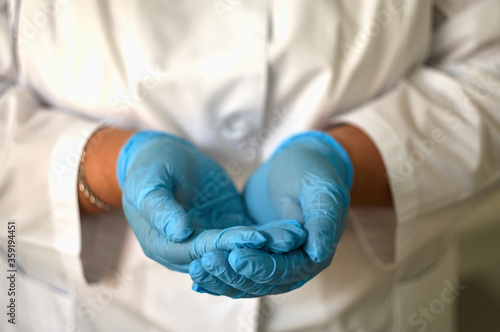 hands of a girl in a lab coat and medical gloves