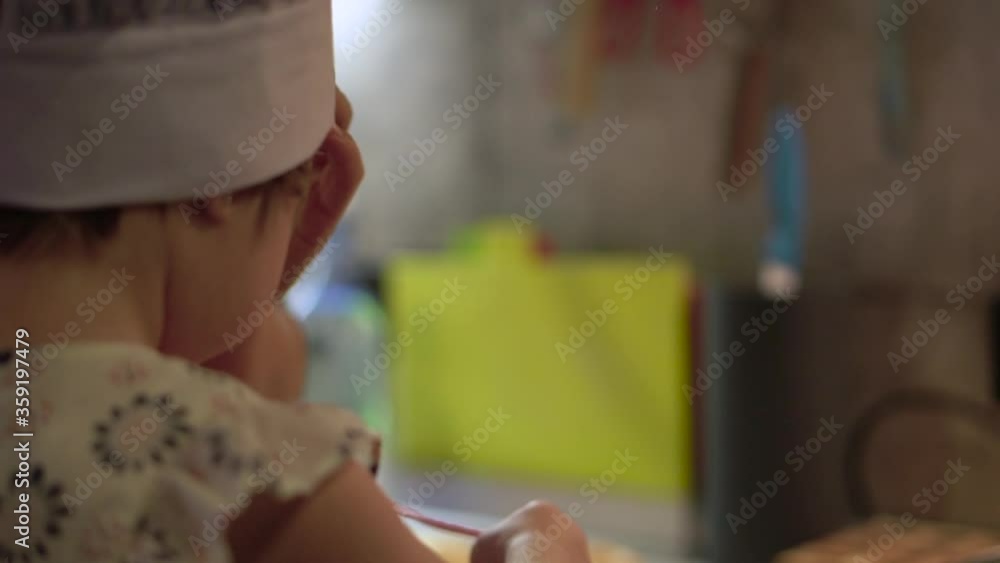 A child in a cook hat. Girl in the kitchen. High quality FullHD footage A child in a cook hat. Girl in the kitchen. High quality FullHD footage