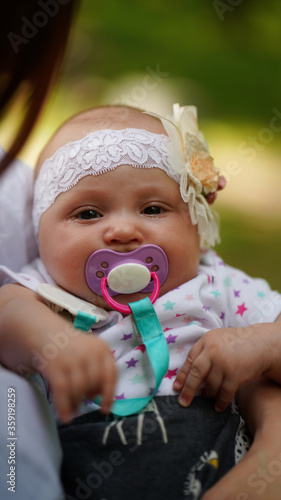 Cute baby with black eyes and bandage on head with pacifier