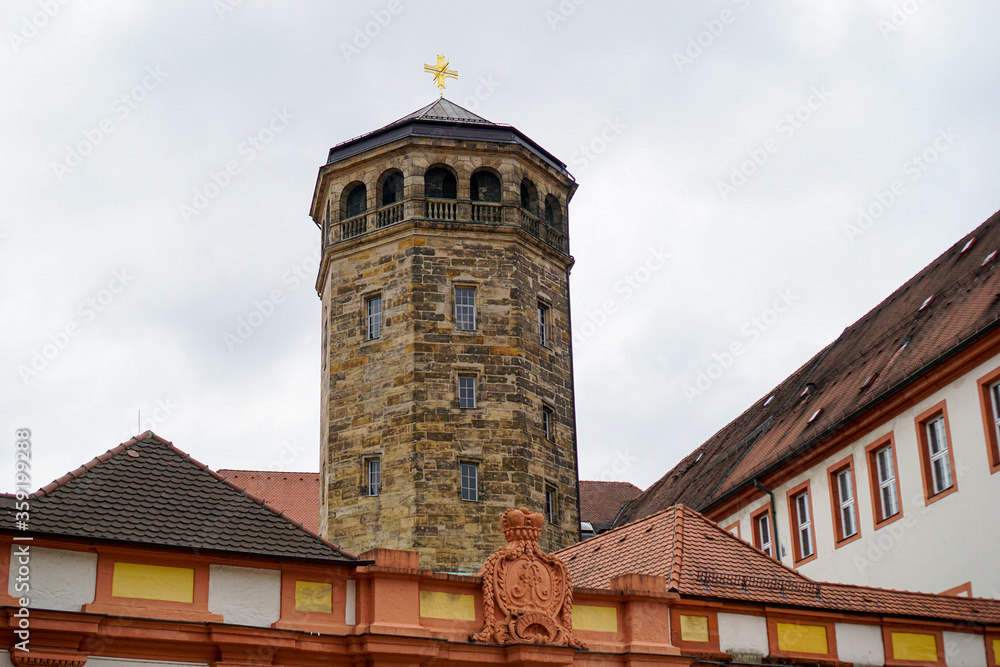 Schlossturm aus Sandstein mit Balkon und Schieferdach und goldenem Kreuz auf der Spitze.  Schlossfassade im Vordergrund. Altes Schloss Bayreuth in Bayern, Deutschland.