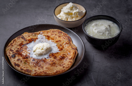 Aaloo parantha or stuffed potato flatbread with curd and white butter