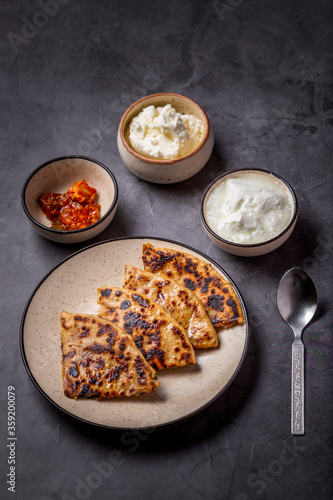 Aaloo parantha or stuffed potato flatbread with curd, pickle and homemade white butter