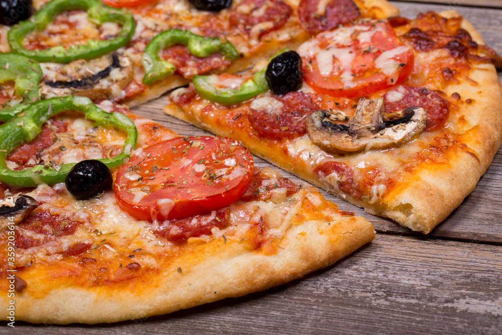 Pizza with a variety of topping on ole wood background Pizza with a variety of topping on ole wood background