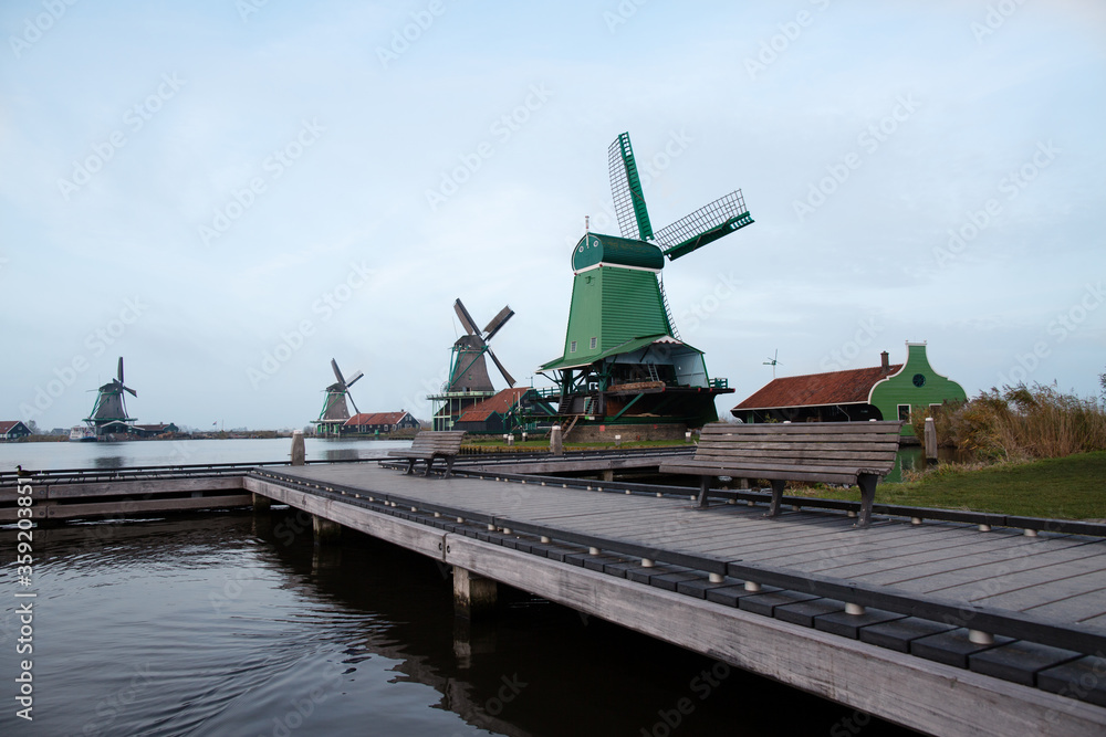 Fototapeta premium Autumn holland village pier with bench and windmills
