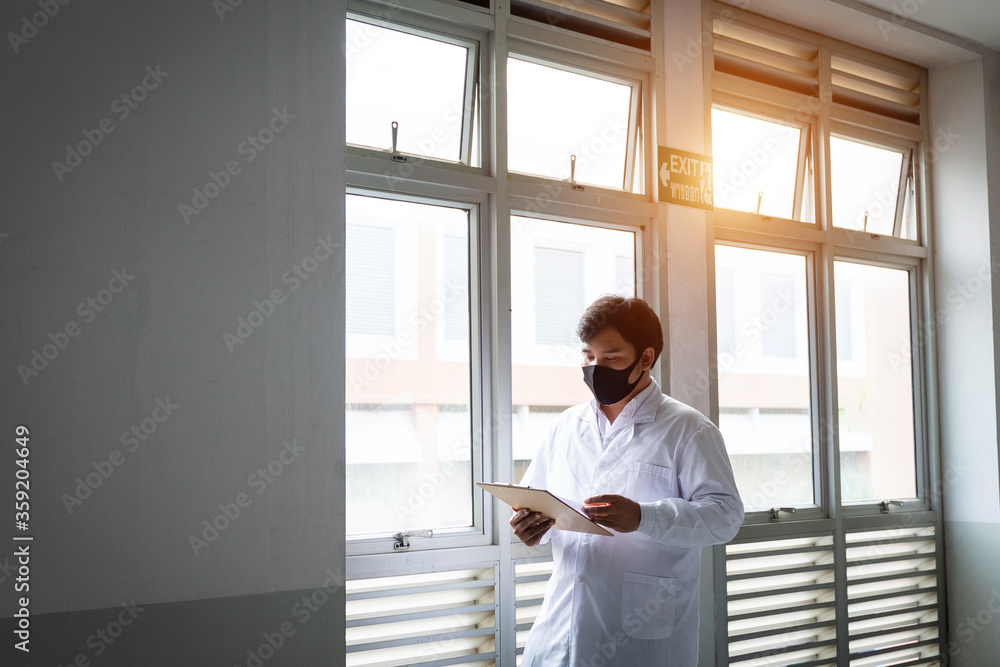 Portrait of a young cheerful and handsome doctor checking patient information and symptoms through tablet and patient documentation. Young confident male doctor portrait. Portrait of a young cheerful and handsome doctor checking patient information and symptoms through tablet and patient documentation. Young confident male doctor portrait.