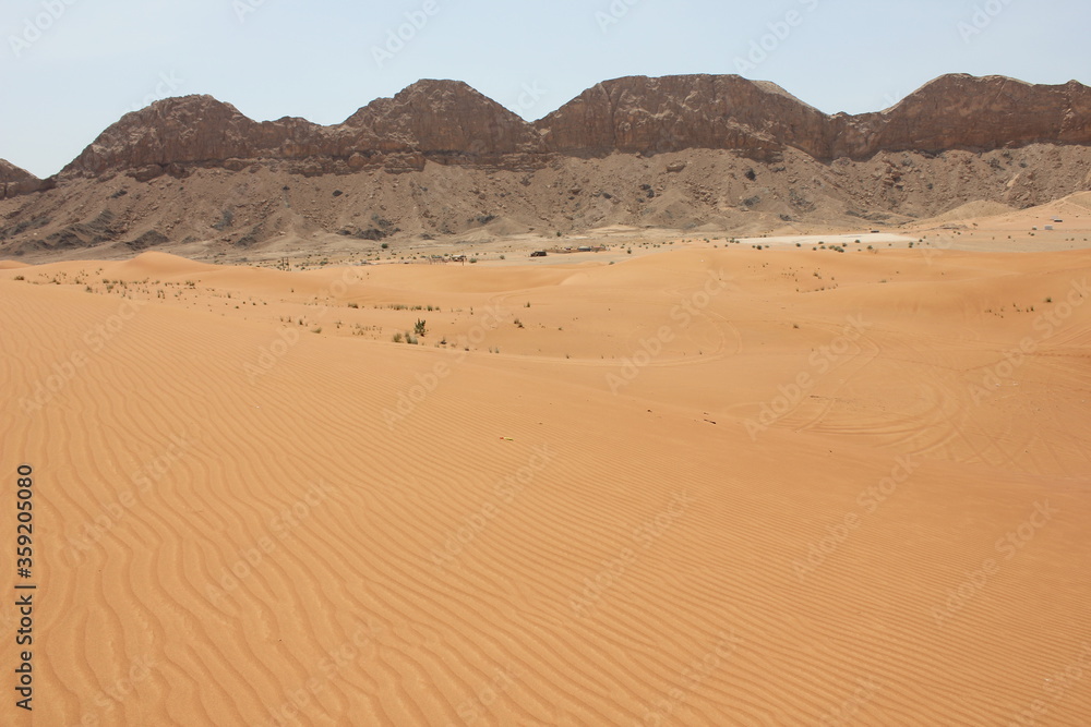 Hot and arid desert sand dunes terrain in Sharjah emirate in the United Arab Emirates. The oil-rich UAE receives less than 4 inches of rainfall a year and relies on water from desalination plants.