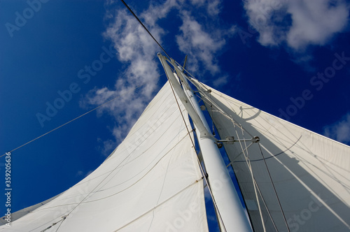 White yacht sail on blue sky background