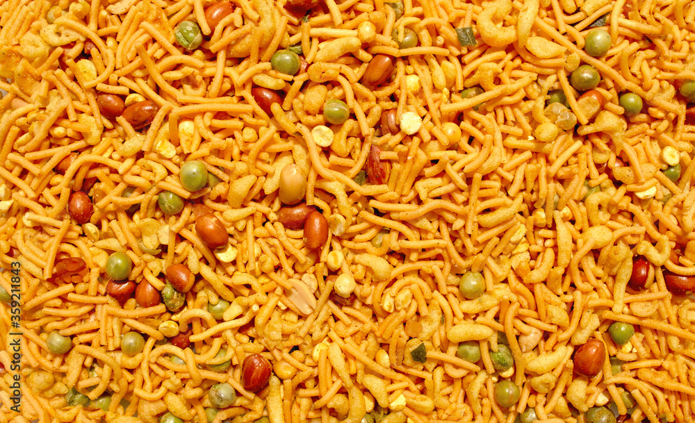 Indian mix snack, deep fried salty dish - chivda made of flour, mixed with roasted nuts, pepper, pulses, spice and green peas. Bombay mix