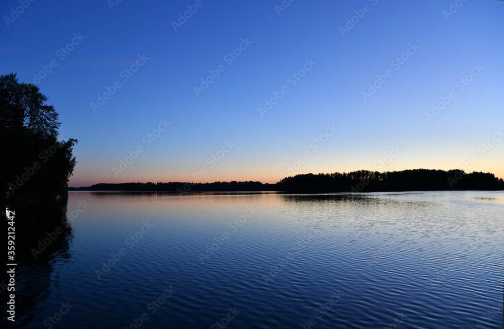 Fototapeta premium reflection of pink clouds in a river at sunrise