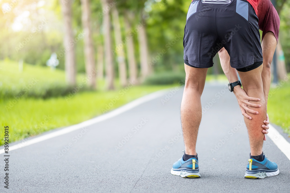 Young adult male with his muscle pain during running. runner man having leg ache due to Calf muscle pull. Sports injuries and medical concept Young adult male with his muscle pain during running. runner man having leg ache due to Calf muscle pull. Sports injuries and medical concept