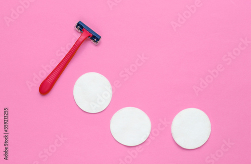Beauty still life, minimalism. Plastic epilator razor with cotton circles on pink background. Women's accessories for beauty care. Top view © splitov27