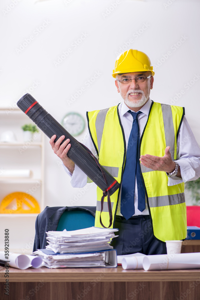 Old male architect working in the office Old male architect working in the office