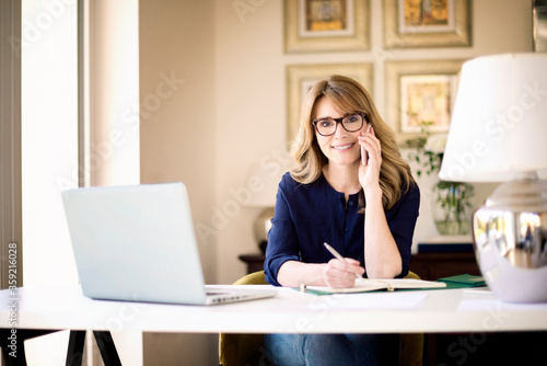 Smiling mature woman working at home