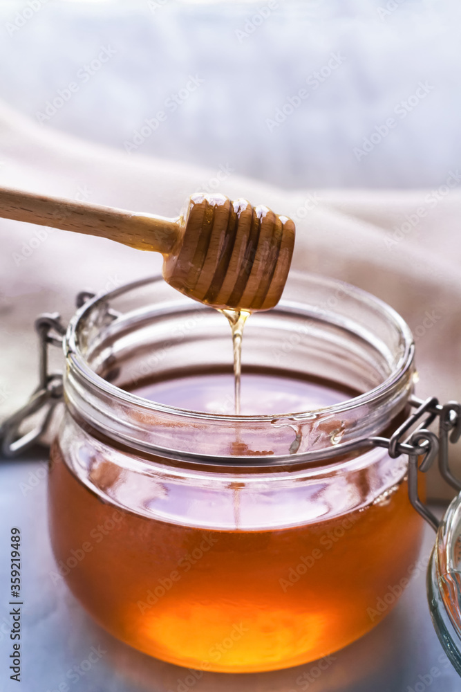 honey in a glass jar on a gray background honey in a glass jar on a gray background