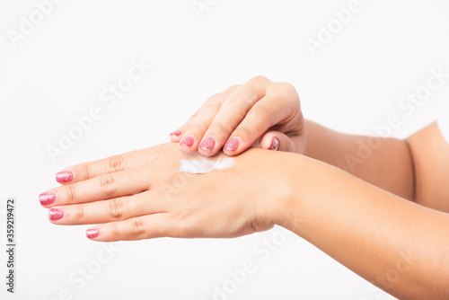 Closeup young Asian woman applying lotion cosmetic moisturizer cream on her behind the palm skin hand, studio shot isolated on white background, Healthcare medical and hygiene skin body care concept