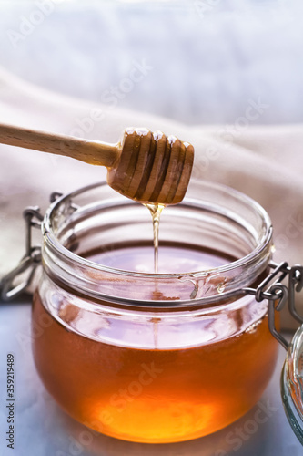 honey in a glass jar on a gray background