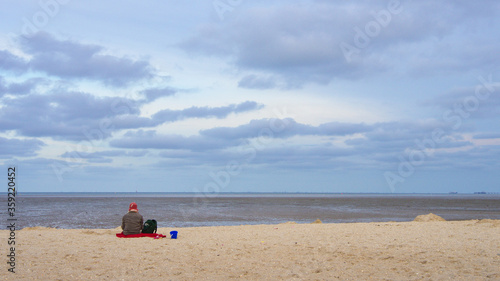 Einsame Frau mit Hund am Strand