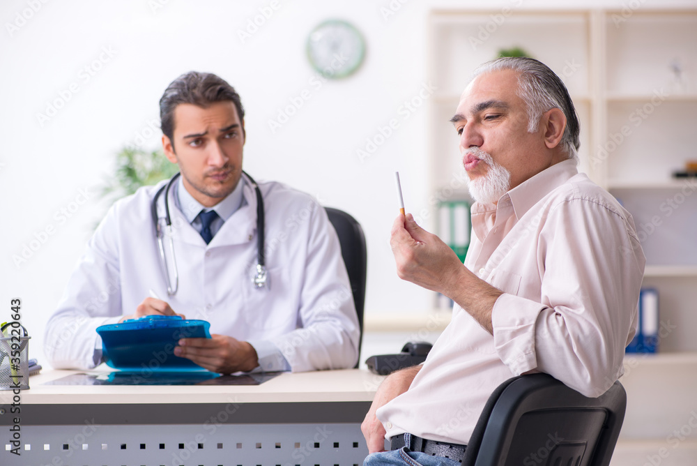 Young male doctor and old patient in antismoking concept Young male doctor and old patient in antismoking concept