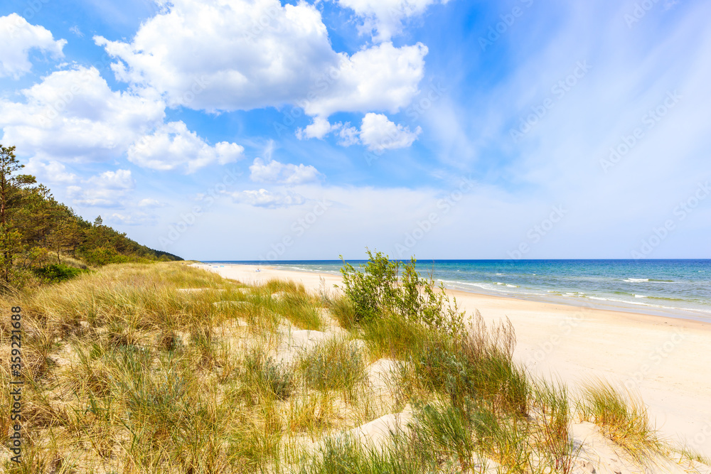 Beautiful white sand beach with dunes and blue sea near Kolobrzeg, Baltic Sea coast, Poland