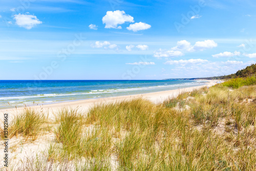 Fototapeta Naklejka Na Ścianę i Meble -  Beautiful white sand beach with dunes and blue sea near Kolobrzeg, Baltic Sea coast, Poland