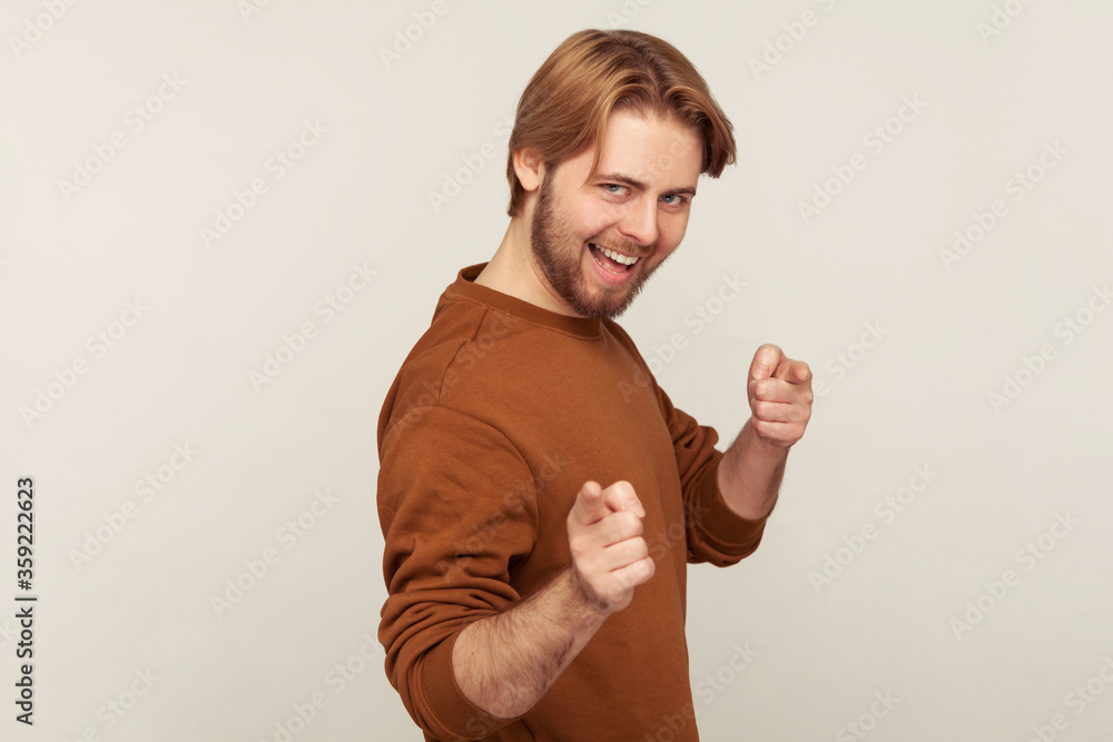 Hey there, we need you! Portrait of carefree cheerful man with beard wearing sweatshirt pointing finger, indicating direction to camera, choosing you for some challenge. indoor studio shot isolated Hey there, we need you! Portrait of carefree cheerful man with beard wearing sweatshirt pointing finger, indicating direction to camera, choosing you for some challenge. indoor studio shot isolated