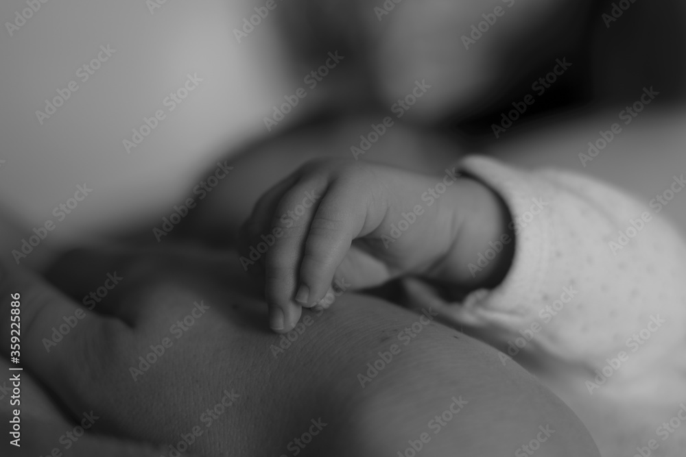 Little fingers of newborn baby with mother's breast. Cute little child with mother's hand. Breastfeeding of Infant. Image with selective focus. Little fingers of newborn baby with mother's breast. Cute little child with mother's hand. Breastfeeding of Infant. Image with selective focus.