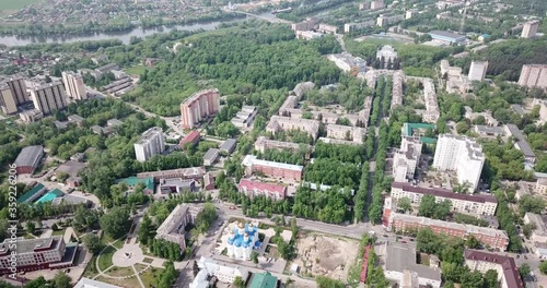 View from drone of Voskresensk cityscape with golden domes of Church of Icon of Our Lady of Jerusalem on spring day, Russia