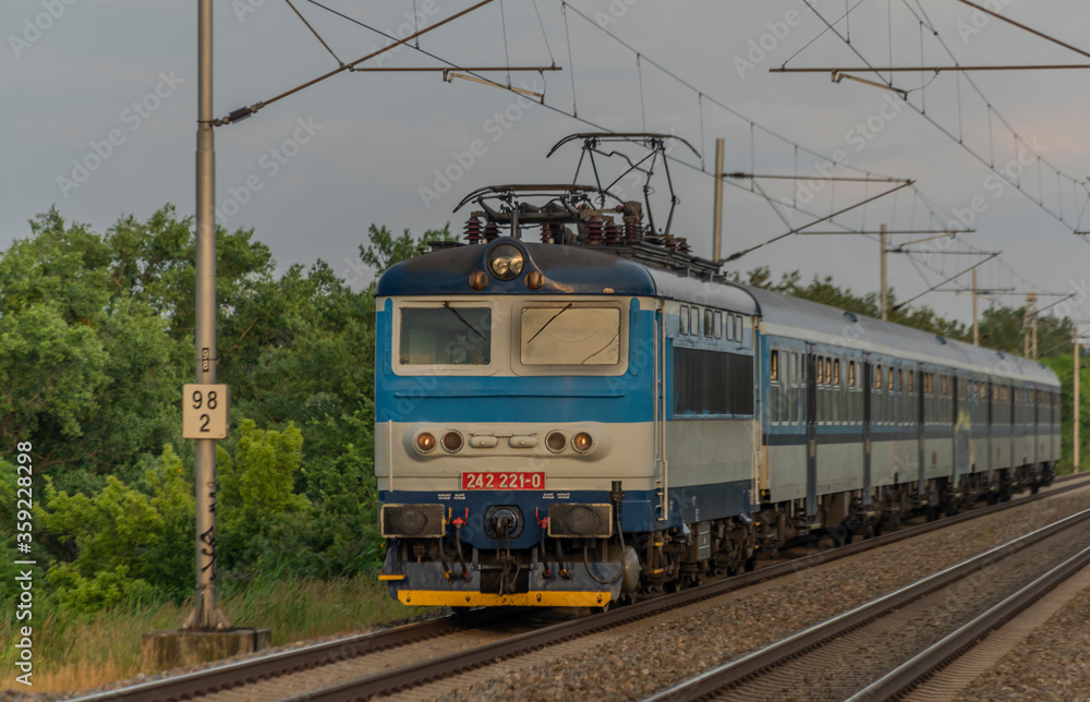Electric blue engine and coaches on fast railway in south of Moravia