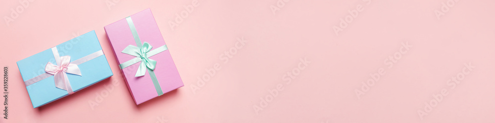 Christmas New Year birthday valentine celebration present romantic concept. Simply minimal design blue pink gift box isolated on pink pastel colorful background. Flat lay top view copy space, banner Christmas New Year birthday valentine celebration present romantic concept. Simply minimal design blue pink gift box isolated on pink pastel colorful background. Flat lay top view copy space, banner