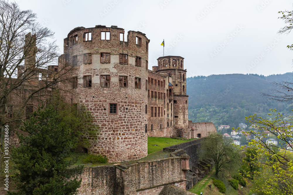 View of the ruin of Heidelberg castle, stone wall, on river side of Neckar, cloudy day spring summer, mountain and forest in background, Heidelberg, Baden-Wuerttemberg (Baden-Wurttemberg) Germany View of the ruin of Heidelberg castle, stone wall, on river side of Neckar, cloudy day spring summer, mountain and forest in background, Heidelberg, Baden-Wuerttemberg (Baden-Wurttemberg) Germany