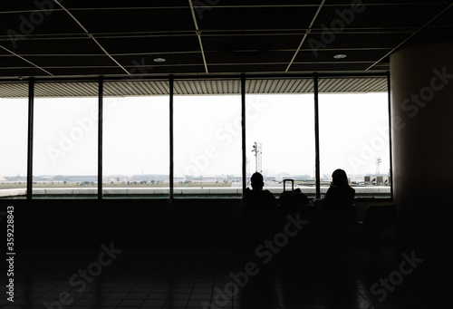 Silhouette of tourists are waiting for boarding time at lounge of donmuang  internation airport bangkok, Thailand. photo