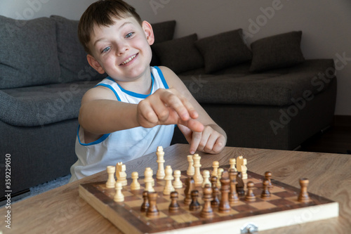 Obraz na płótnie Cheerful child plays chess. A fun game with children in chess w salonie