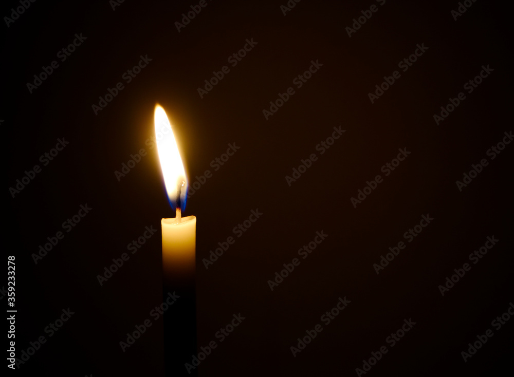 burning candle in the dark , a single candle is lit. burning candle in the dark , a single candle is lit.