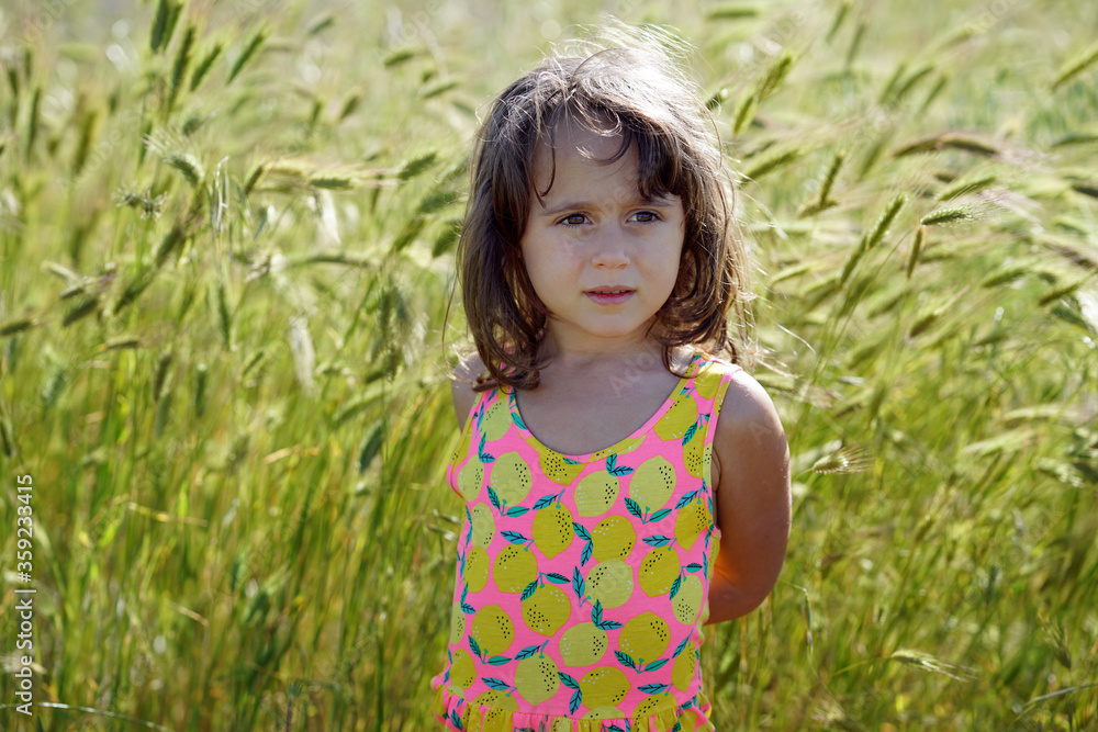 Portrait of an little girl with a background of green spikes Portrait of an little girl with a background of green spikes
