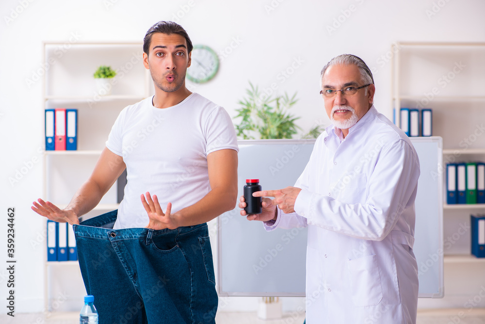 Doctor dietician and happy patient wearing large trousers Doctor dietician and happy patient wearing large trousers