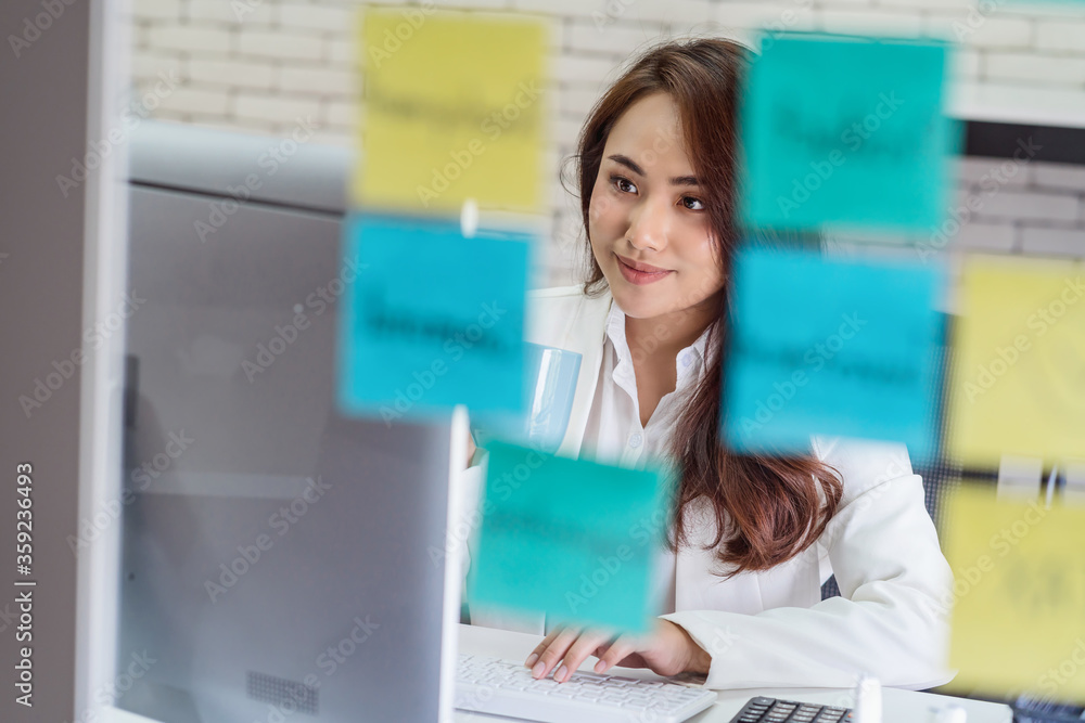 Asian Business woman holding coffee cup and working with technology computer and memo note on the mirror in happiness action at office or coworking space,startup and entrepreneur,workshop and strategy Asian Business woman holding coffee cup and working with technology computer and memo note on the mirror in happiness action at office or coworking space,startup and entrepreneur,workshop and strategy
