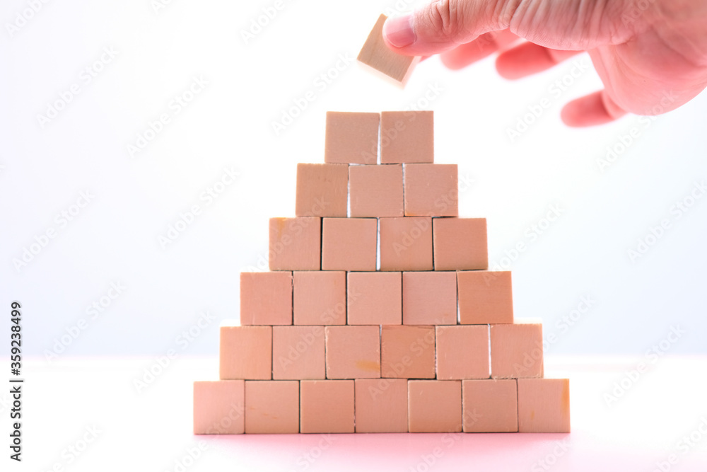 Businessman hand arranging wood cube stacking as step stair. Business concept growth success process and business word on table background and teamwork concept