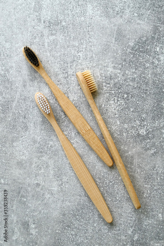 Eco-friendly bamboo toothbrushes on concrete stone background. Natural organic bathroom beauty product concept. Flat lay, top view.