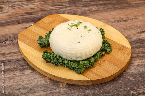 Caucasian suluguni round cheese piece