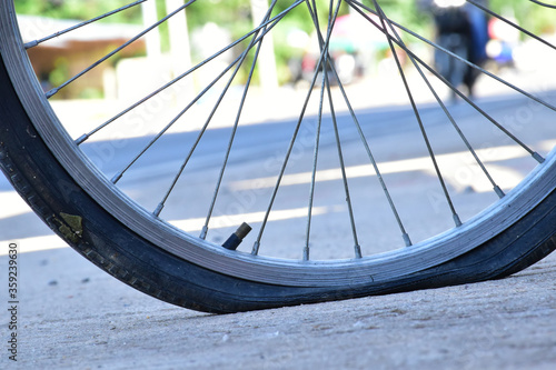 Closeup view of bicycle flat tire on pavement.