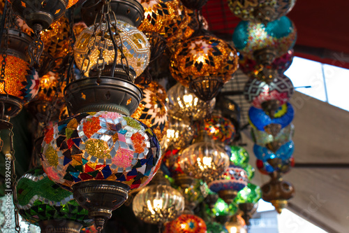 round colored lamps made of glass. the light, which is hand-crafted in glass with Anatolian motifs. colorful decorative old-type lamps hung up in front of the shop.