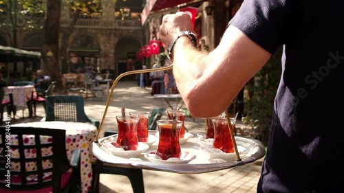 Waiter delivering traditional Turkish tea on a tray photo