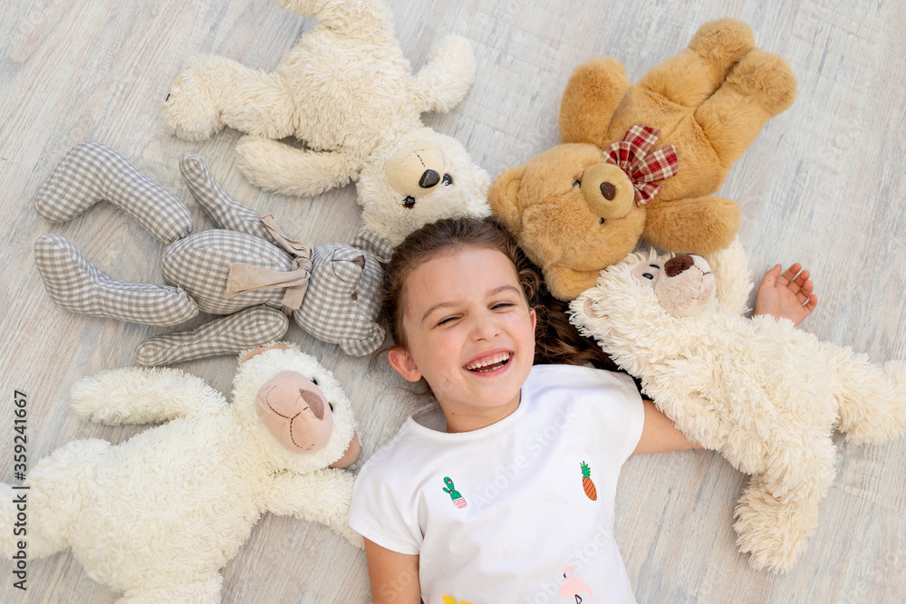a little girl 5-6 years old lies among Teddy bears a little girl 5-6 years old lies among Teddy bears