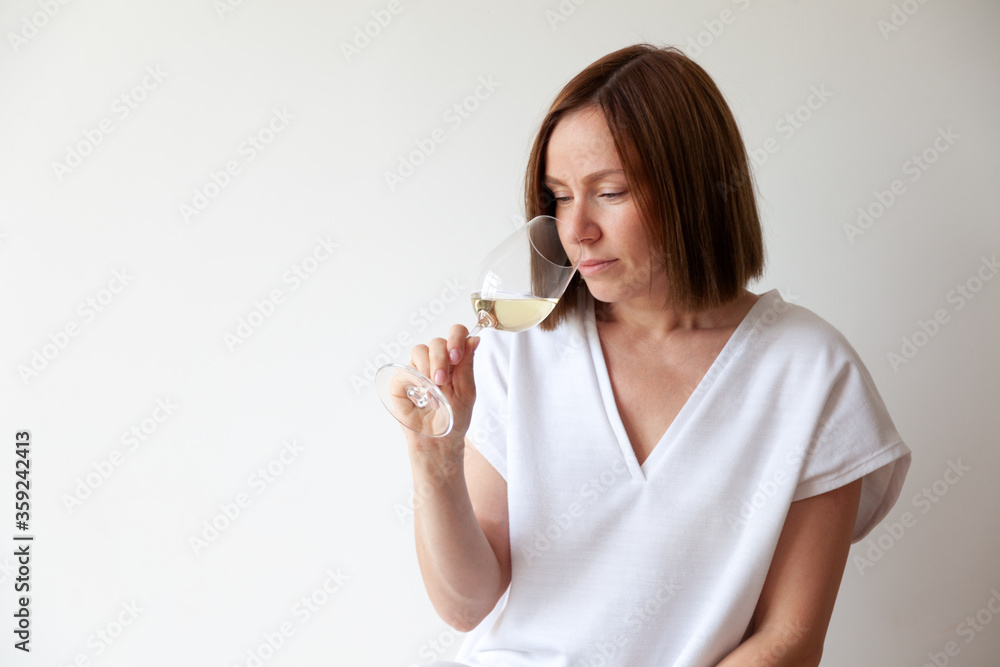 Caucasian brunette girl sommelier holding glass of white wine Caucasian brunette girl sommelier holding glass of white wine