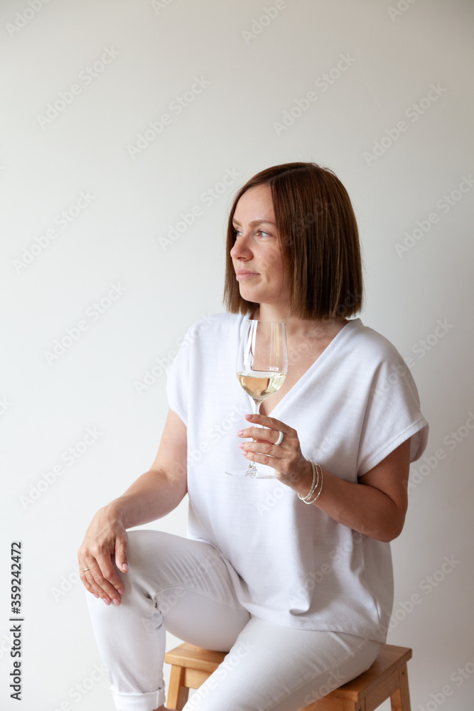 Caucasian brunette girl sommelier holding glass of white wine Caucasian brunette girl sommelier holding glass of white wine