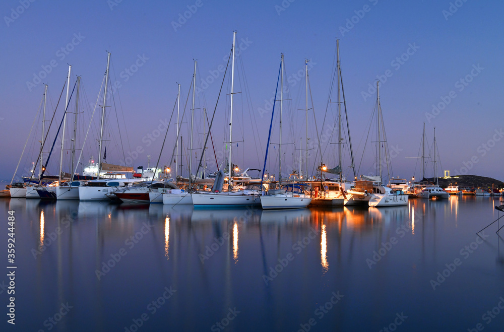 A group of yachts on a pier in the port in the early morning.