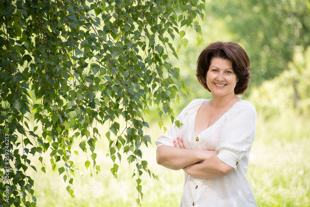 Russian woman near the birch in the summer Russian woman near the birch in the summer